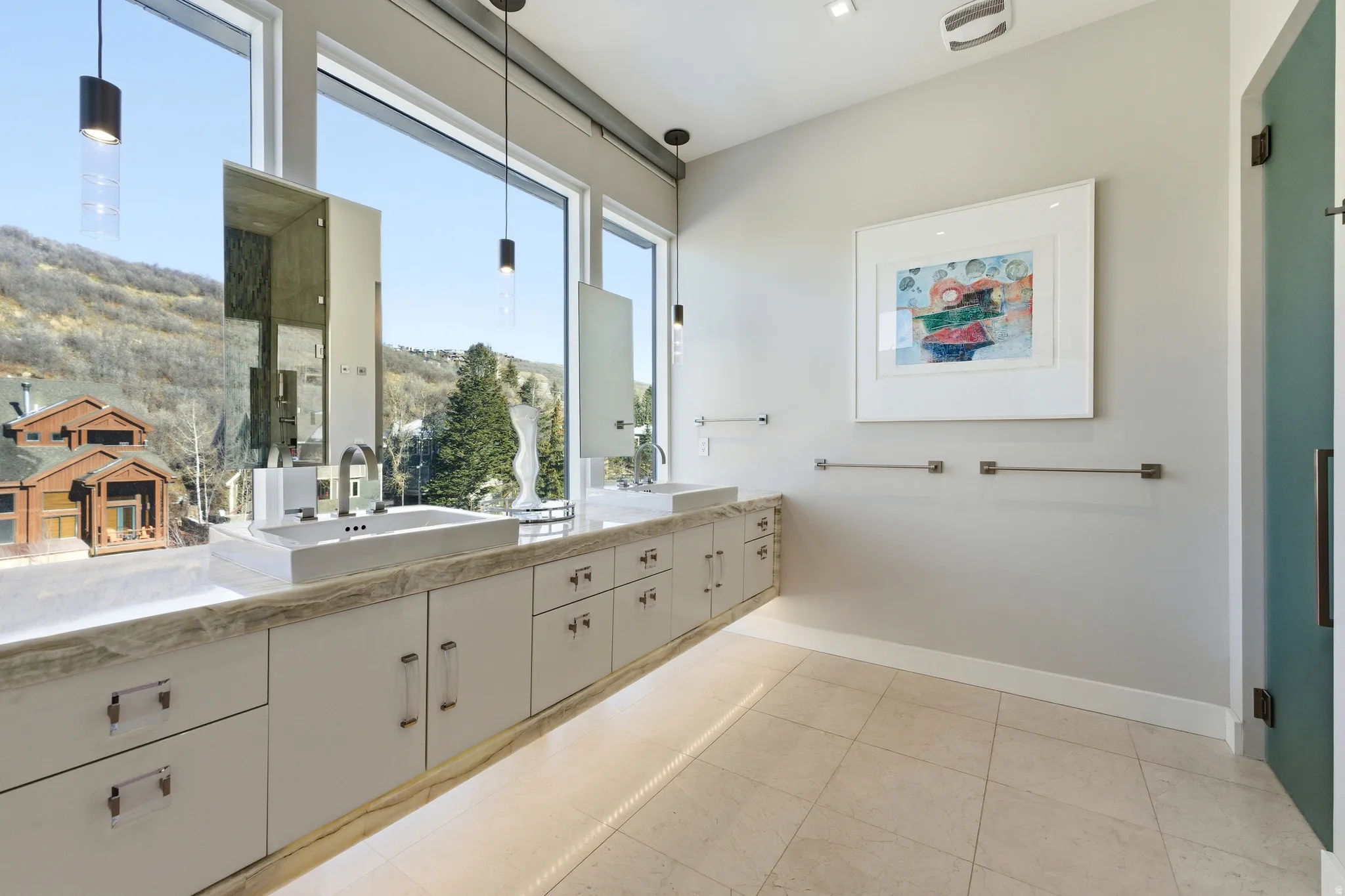 Contemporary bathroom featuring a dual vanity with rectangular vessel sinks, extensive light-toned cabinetry, and a stone-finish countertop