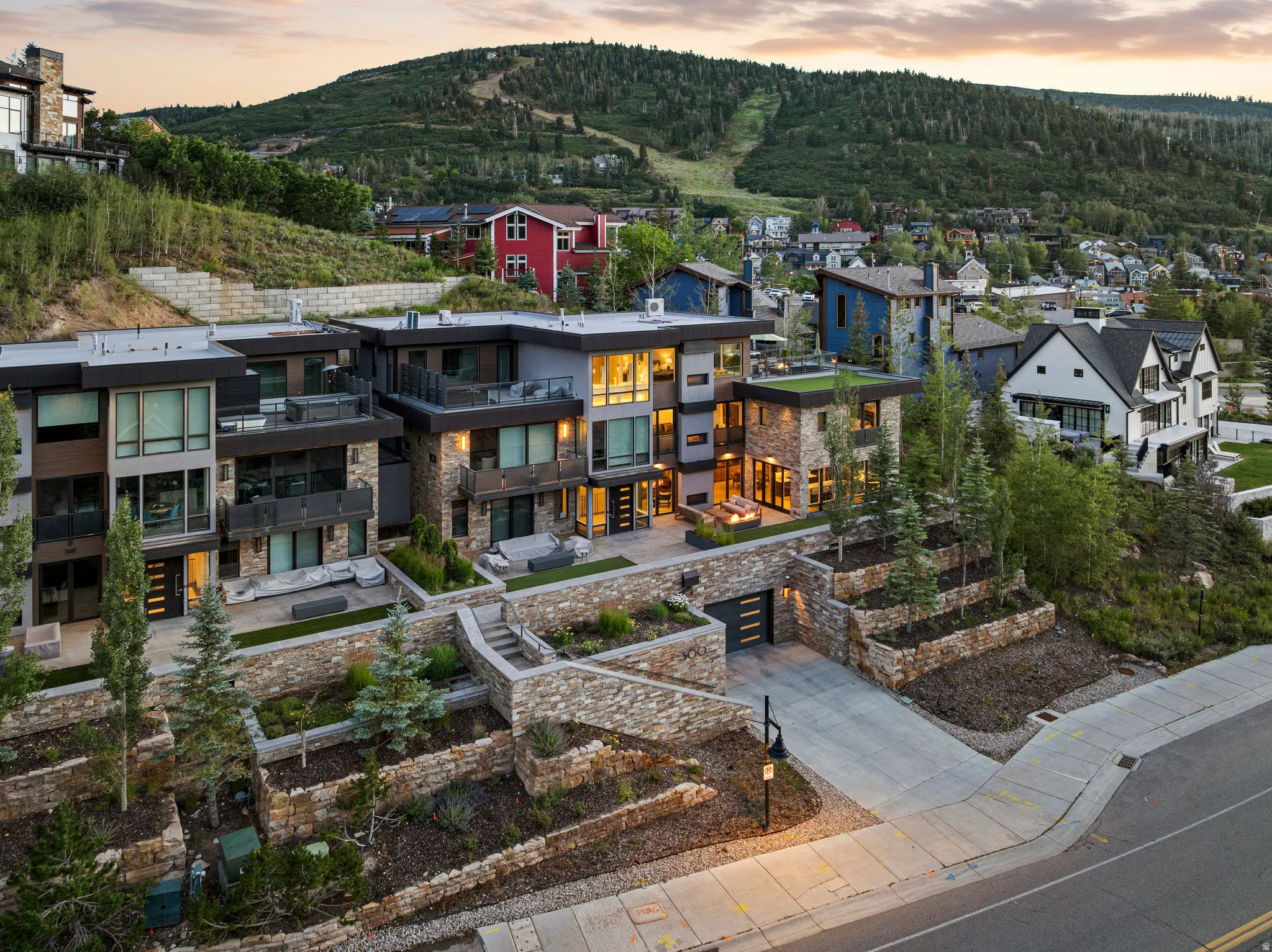 Contemporary multi-level exterior featuring stacked stone accents and dark-framed windows