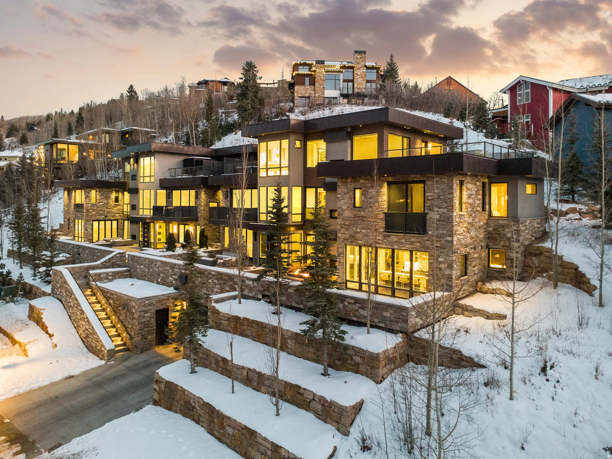 Multi-level contemporary residence featuring extensive stone cladding and expansive window walls