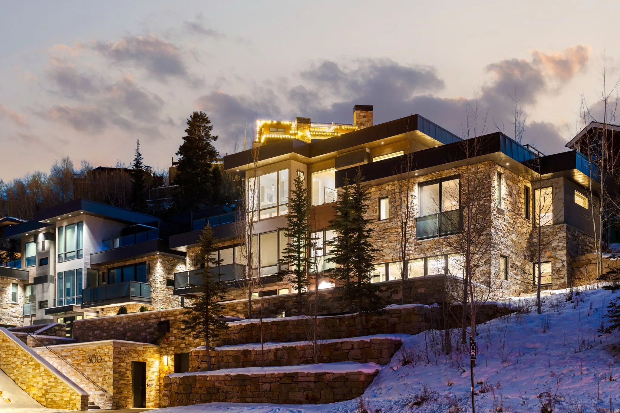 Multi-level contemporary residence featuring stone and dark panel exteriors