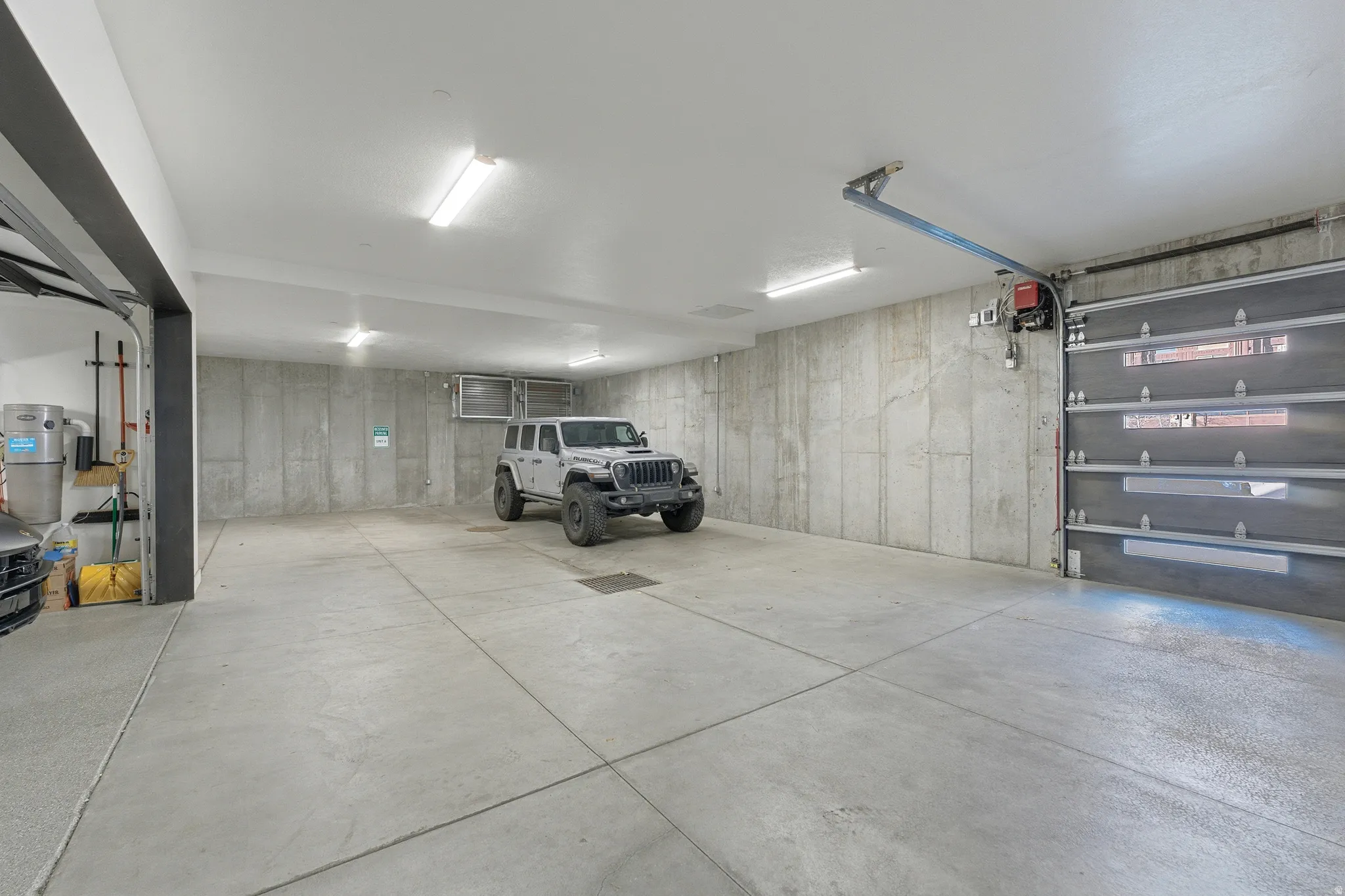 Spacious garage with concrete flooring and exposed concrete walls