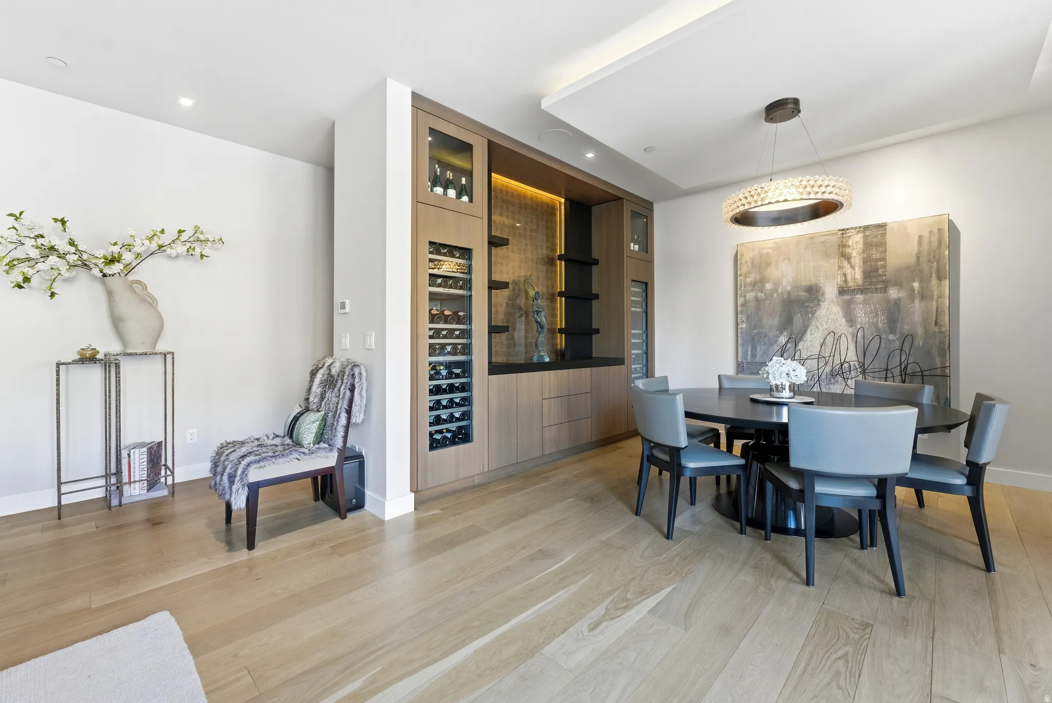 Integrated custom cabinetry with wine refrigeration, recessed lighting, and accent shelving