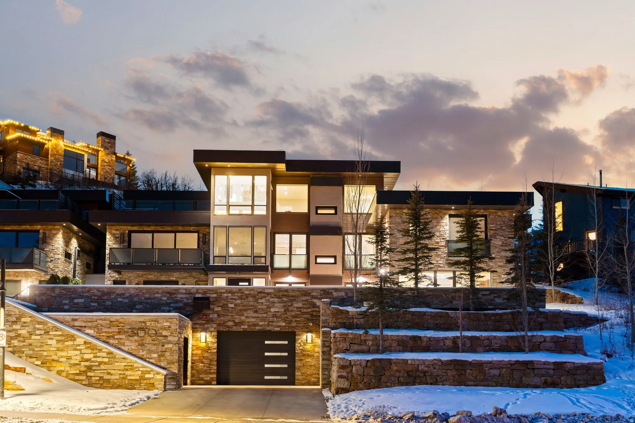 Contemporary architecture featuring extensive stone veneer siding and broad window expanses