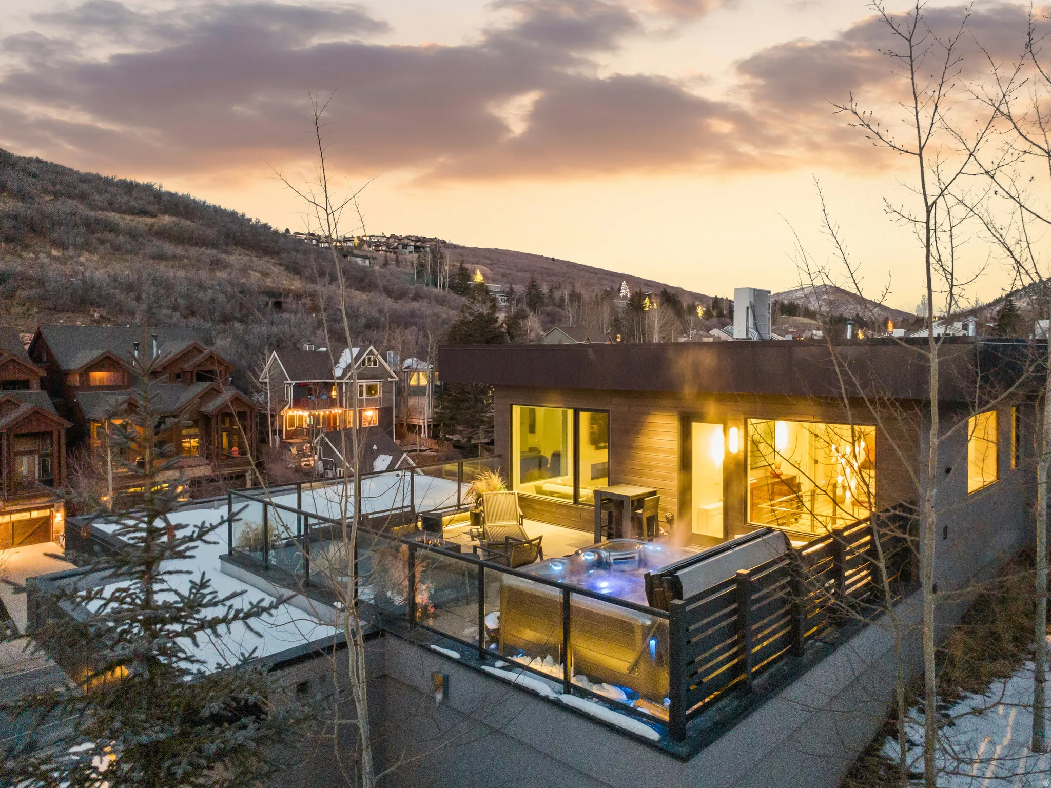 Rooftop terrace featuring a hot tub, glass railing, and outdoor seating