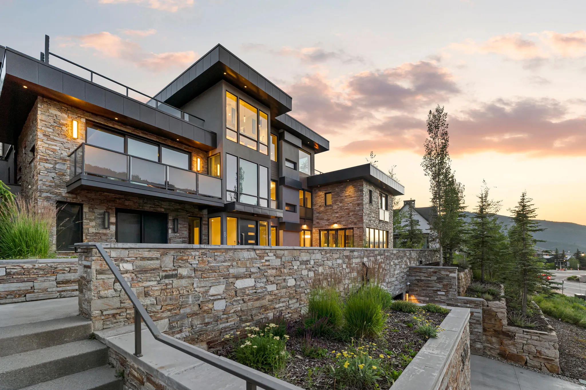 Modern architectural exterior featuring stone veneer and dark-toned siding