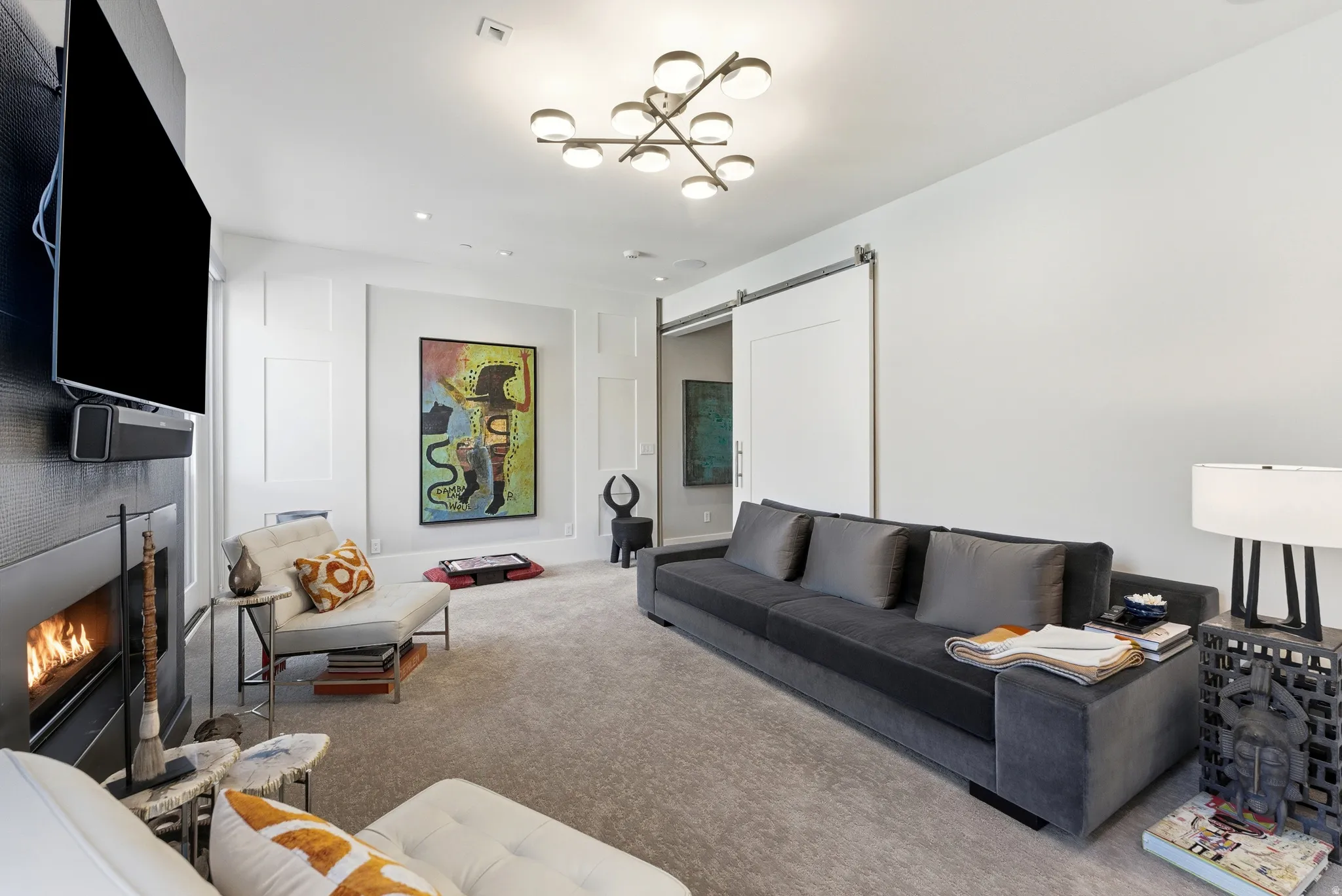 Living area featuring a modern fireplace with a black surround, recessed lighting, and a contemporary ceiling fixture
