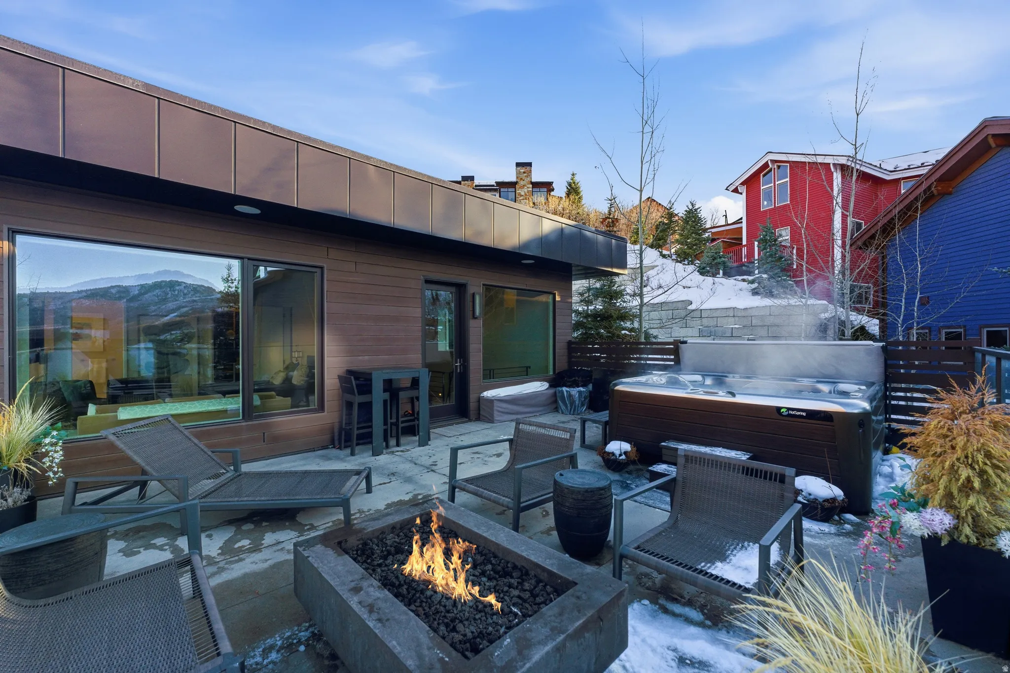 Outdoor patio featuring a built-in fire pit, a hot tub, and a large sliding glass door