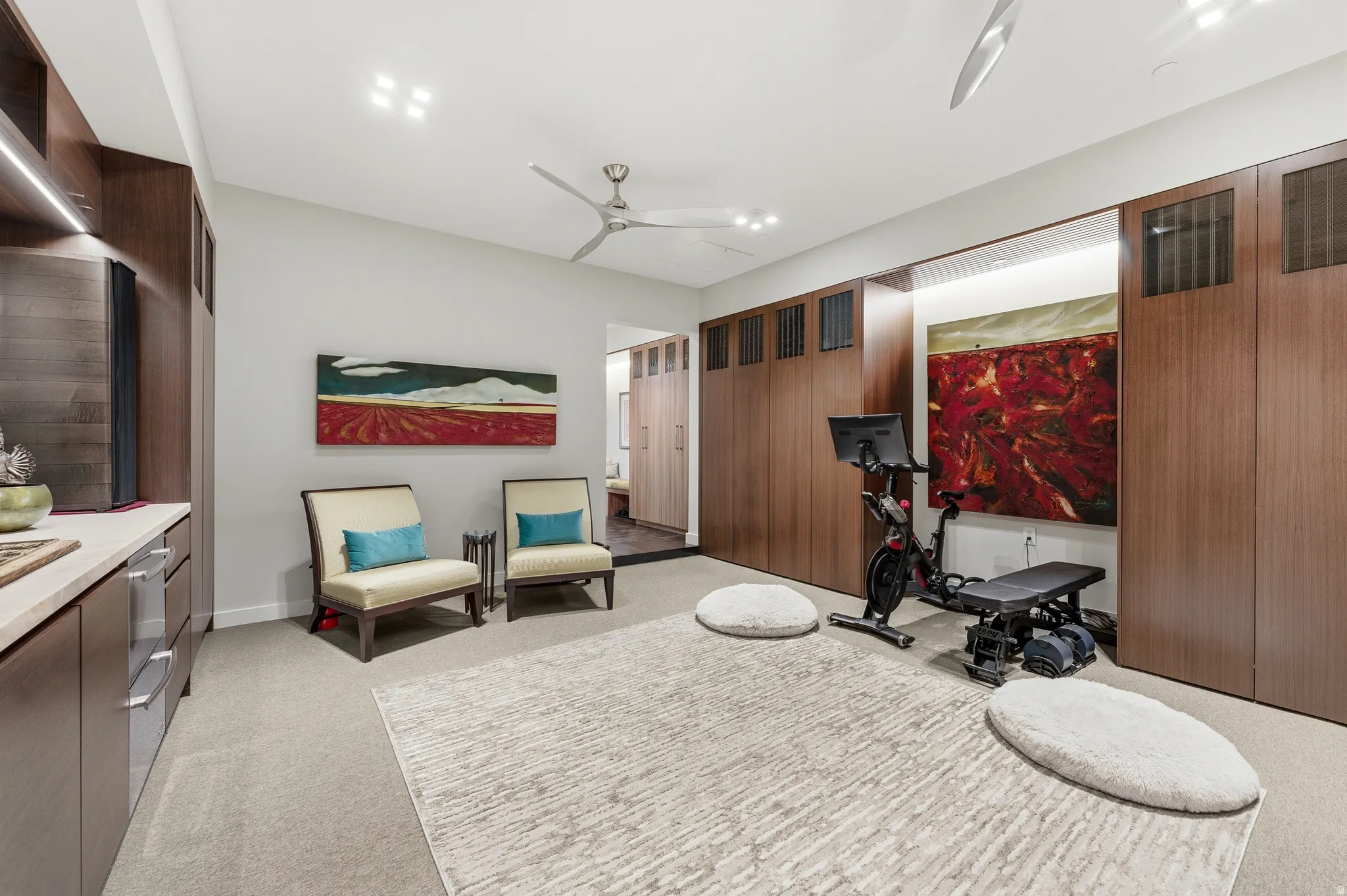 Carpeted room featuring extensive built-in cabinetry with wood-finish panels