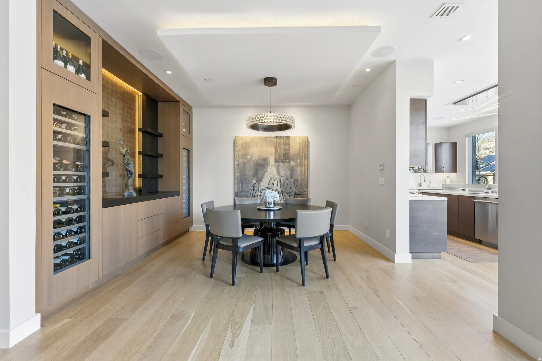 Dining area featuring a built-in custom bar with wine refrigeration, integrated lighting, and a suspended ceiling detail