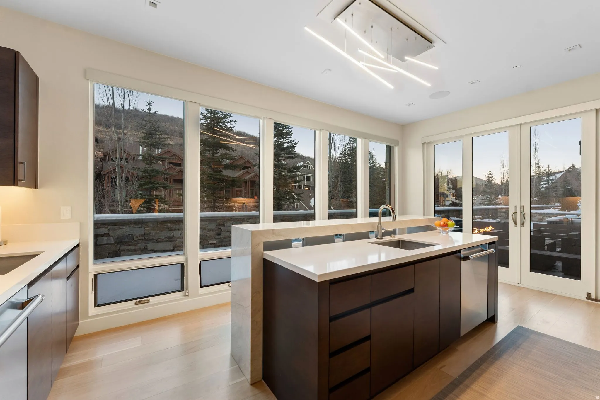 Modern kitchen featuring an island with an integrated sink and stainless steel dishwasher