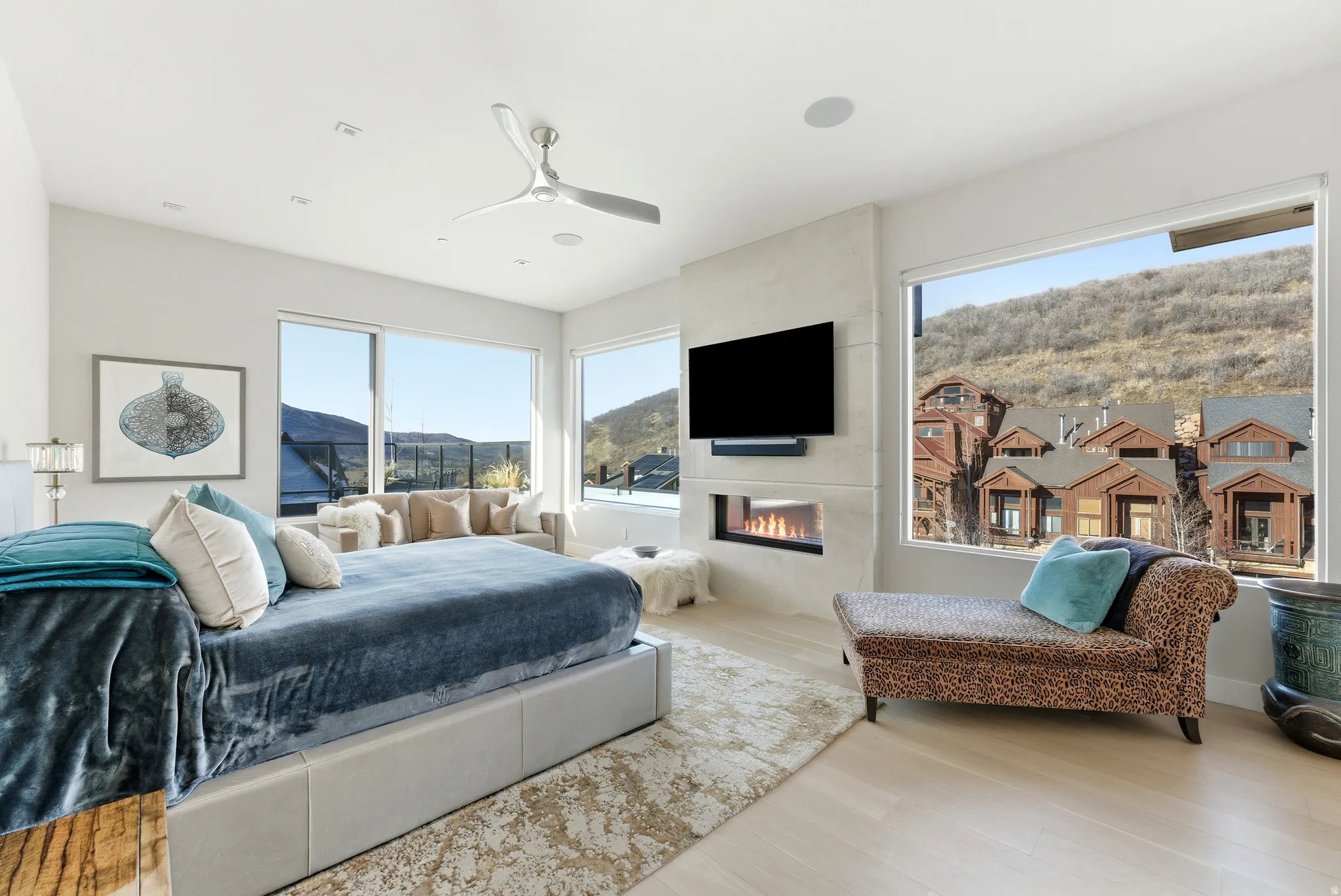 Spacious interior featuring expansive windows, a built-in fireplace, recessed lighting, and a ceiling fan