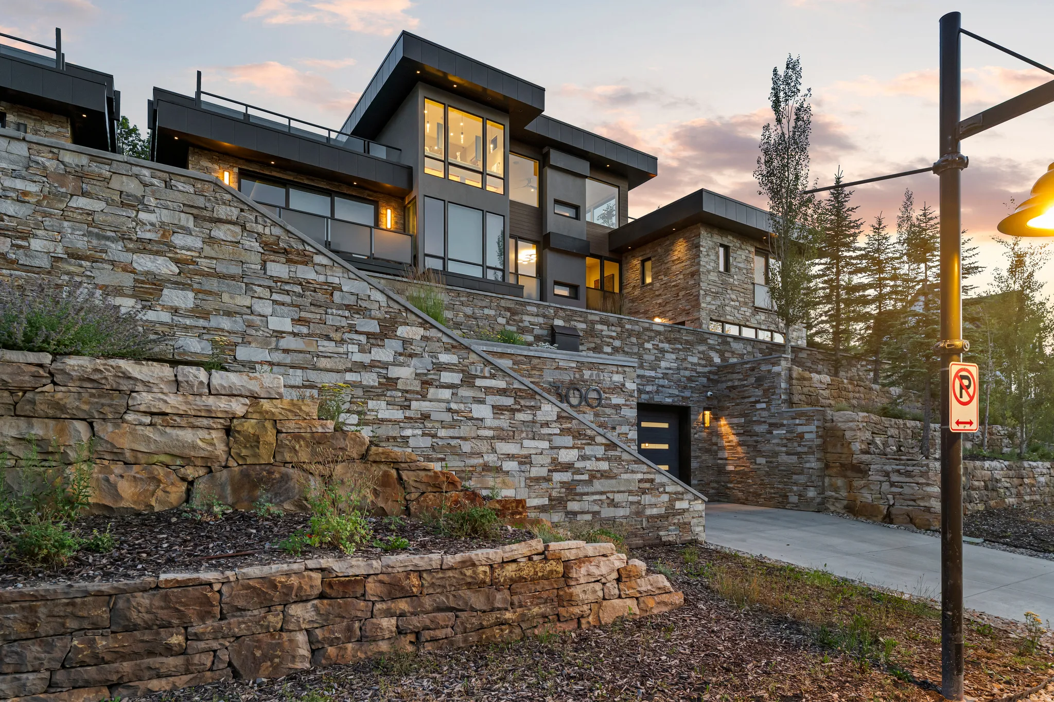 Multi-level modern residence featuring extensive stone wall landscaping