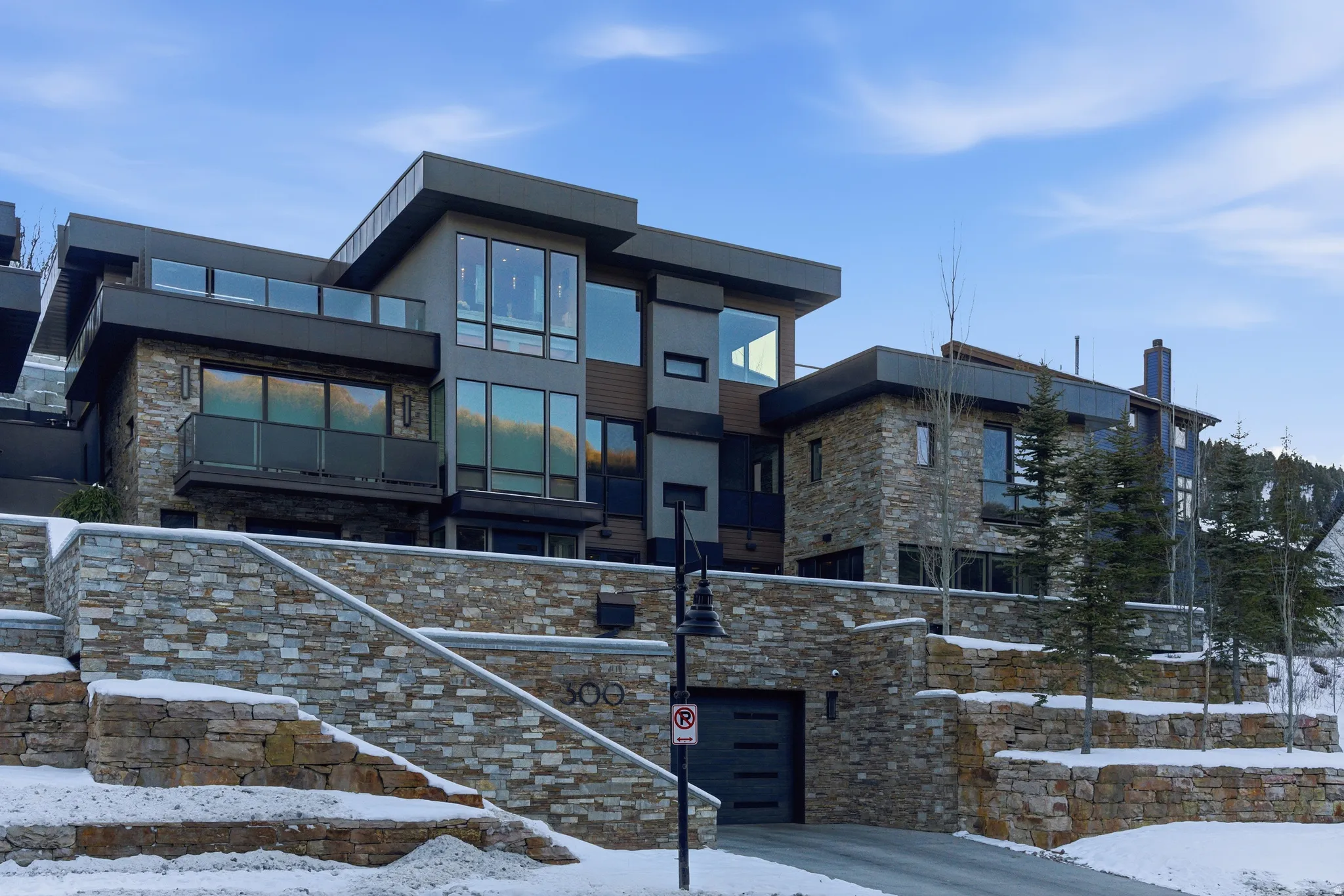 Contemporary multi-level residence featuring extensive stonework and large windows