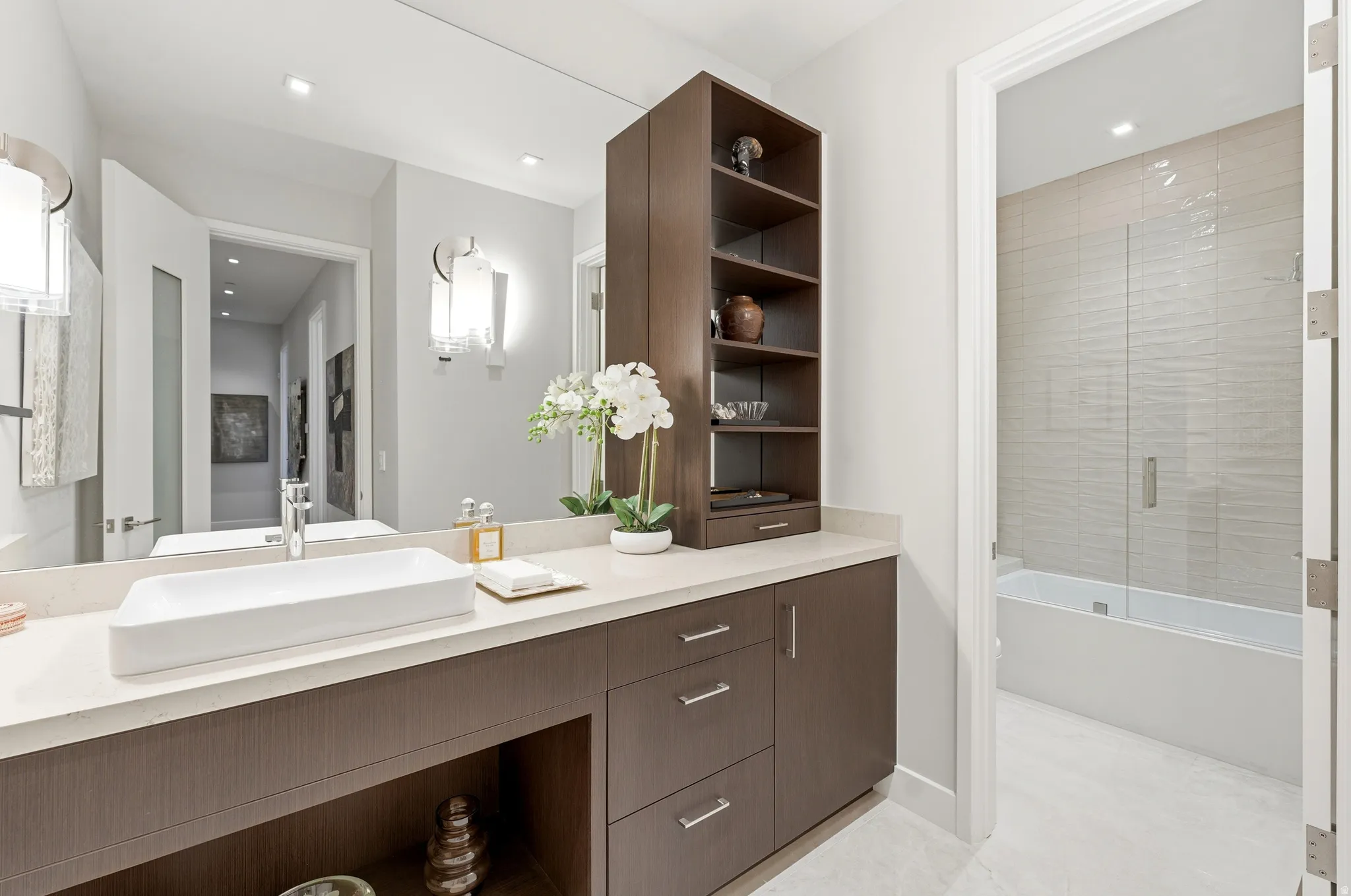 Bathroom vanity featuring a rectangular vessel sink, polished chrome faucet, full-width mirror, and a light-toned countertop