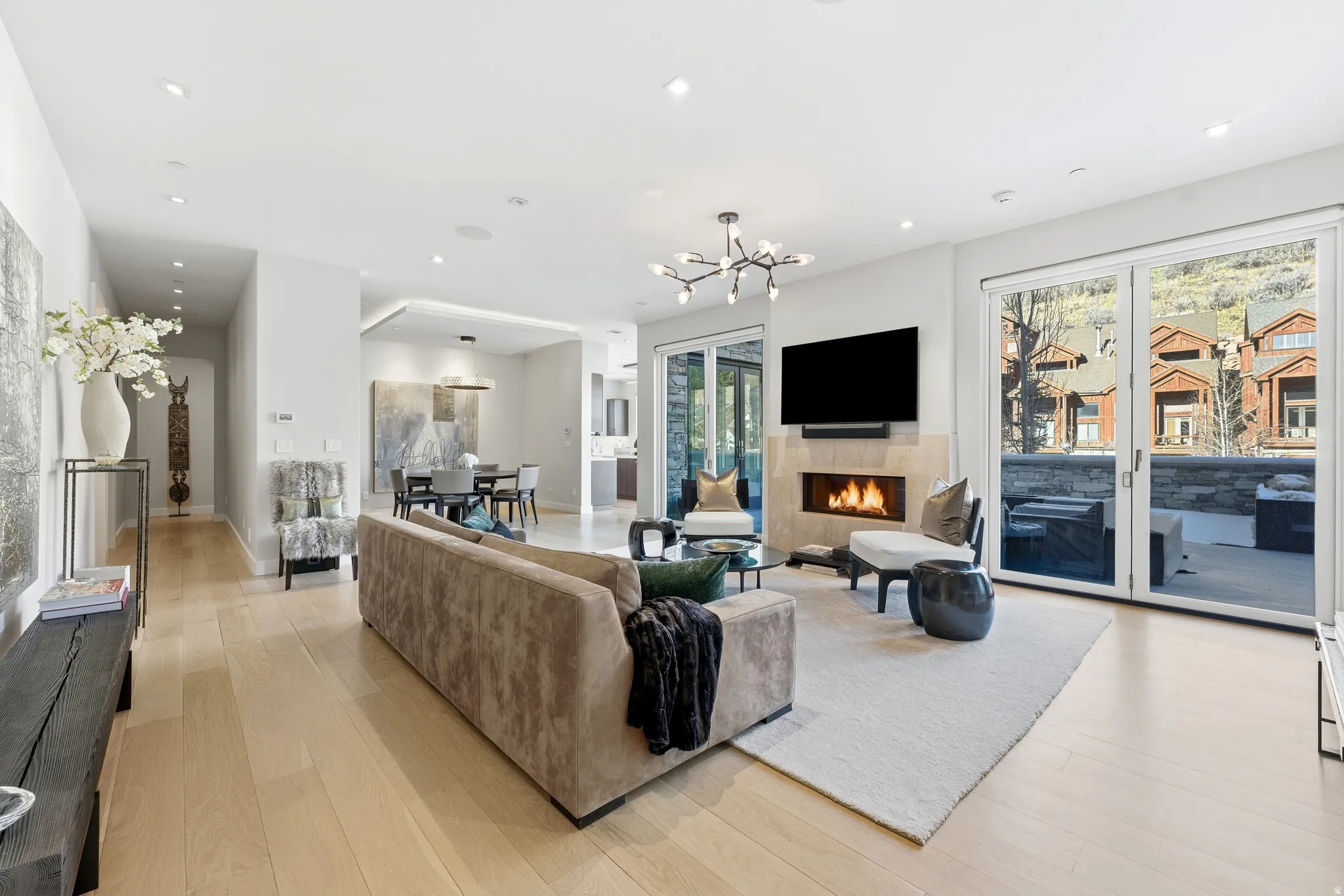 Open-concept living space featuring wood-finish flooring, recessed lighting, and a modern chandelier