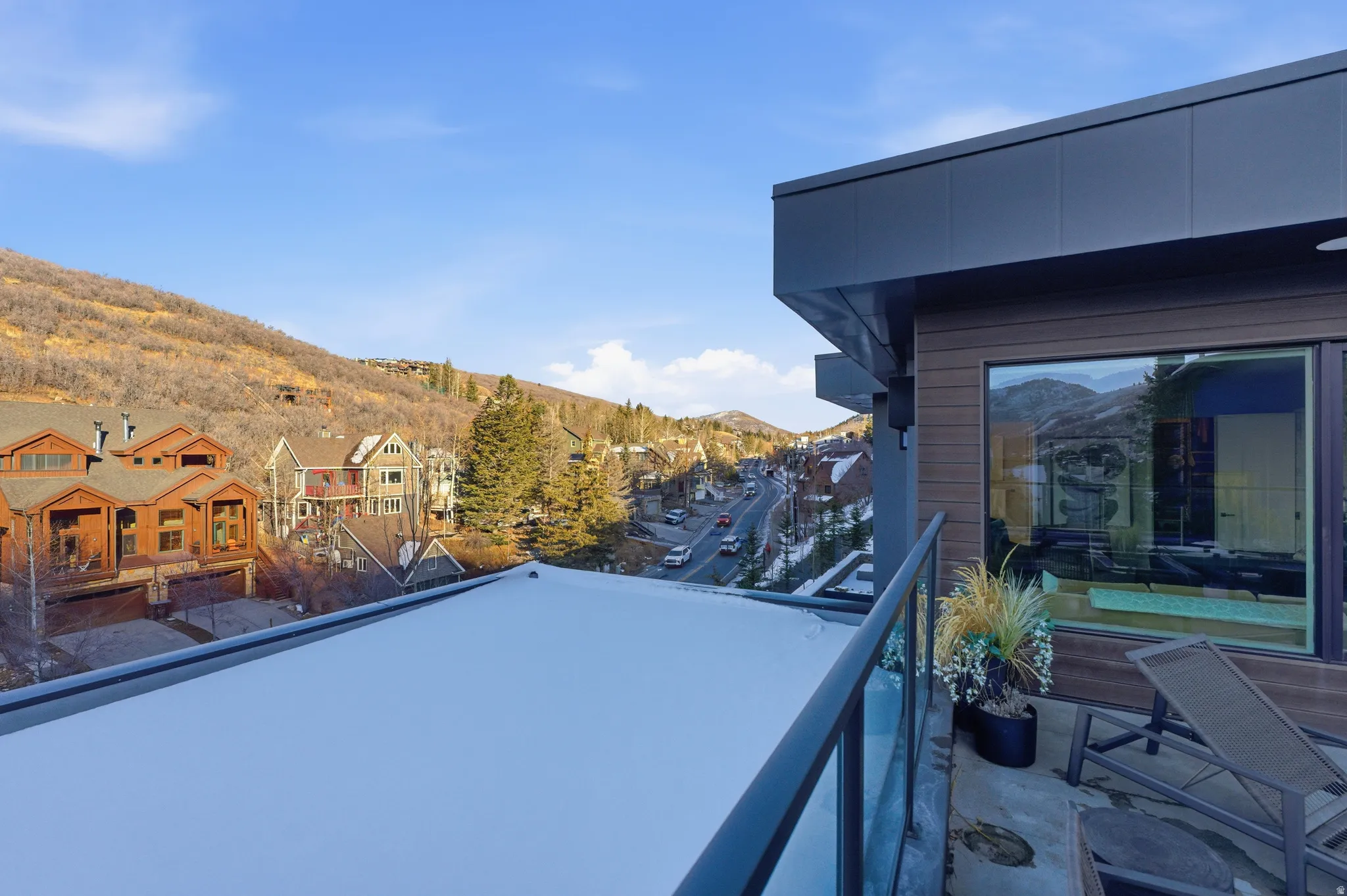 Balcony featuring a glass railing, dark metal framing, and a sliding glass door