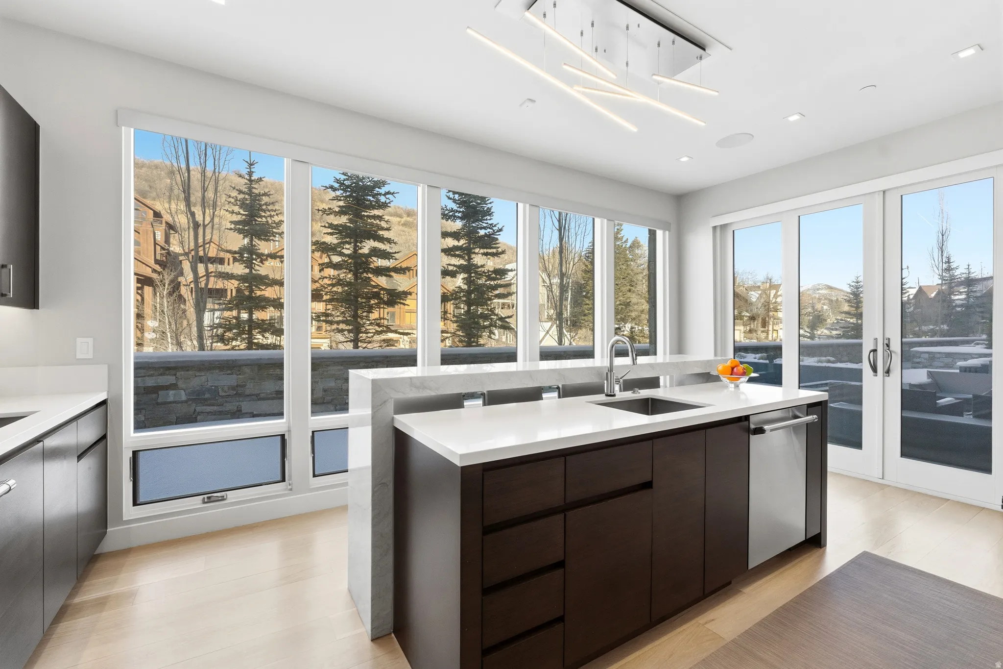 Contemporary kitchen island with an integrated sink and stainless steel dishwasher