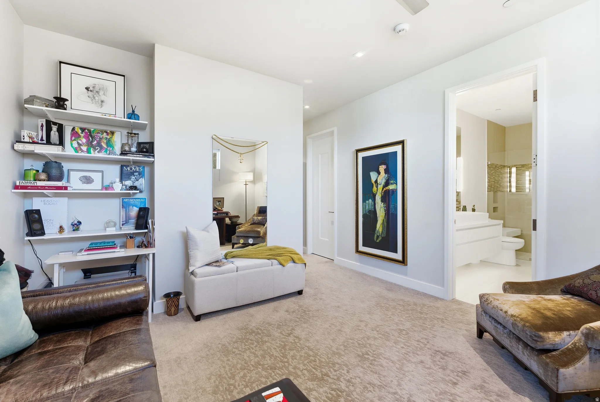 Plush carpeting throughout this interior space, featuring a built-in shelving unit, a neutral color palette, a doorway to an additional room, and a ceiling-mounted smoke detector