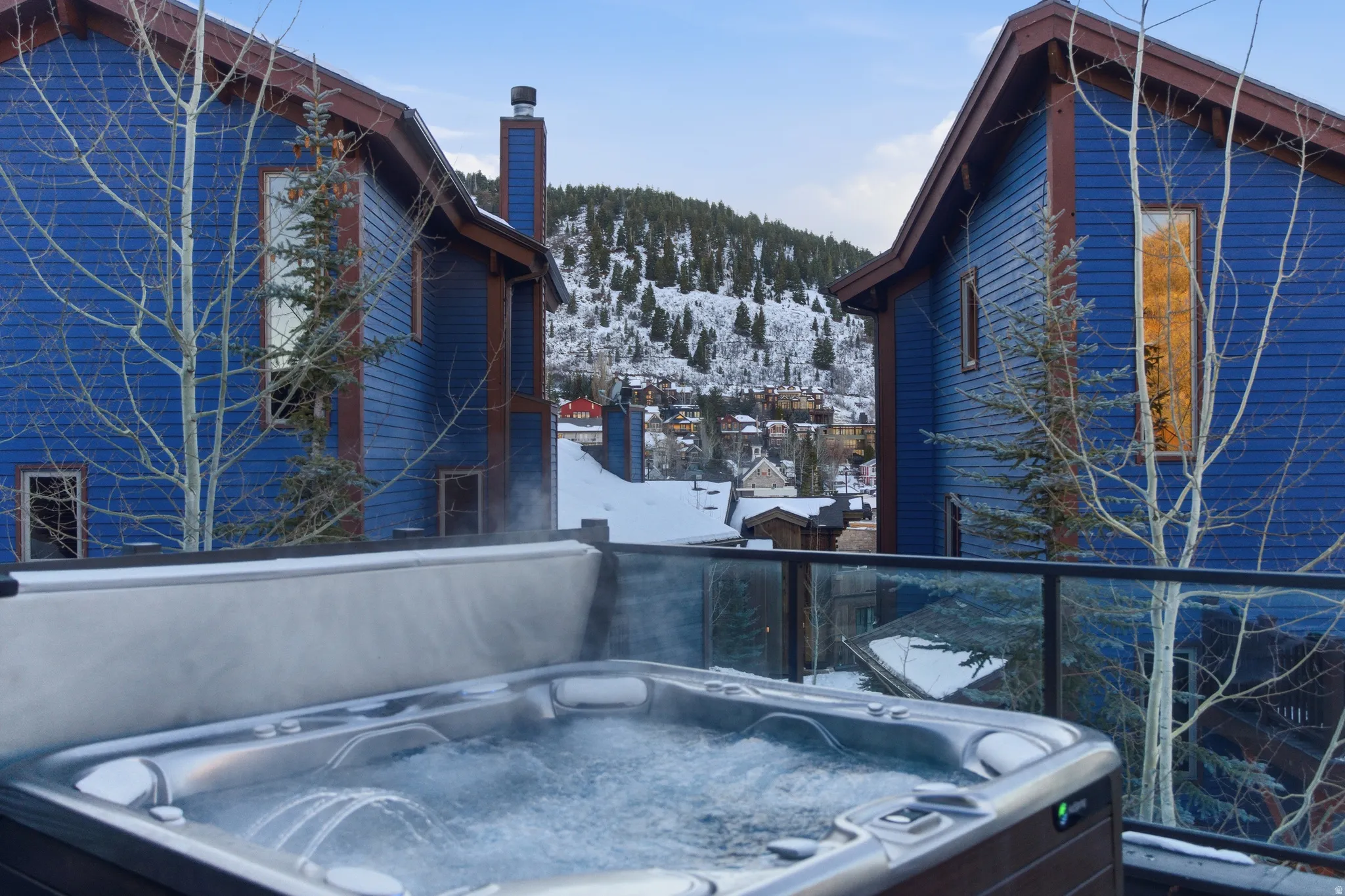 Outdoor spa with bubbling water, set on a deck with glass railings