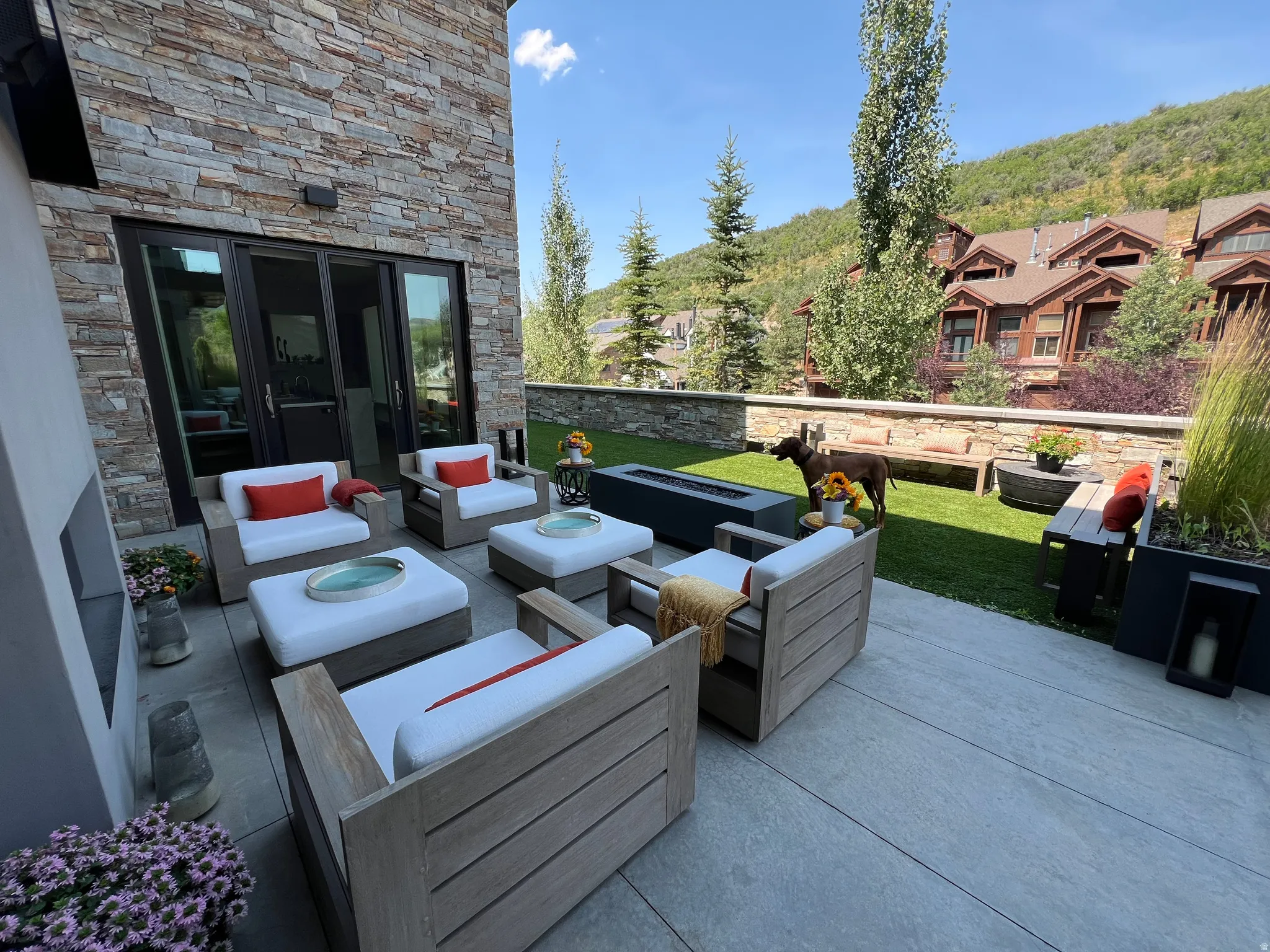Expansive outdoor patio featuring large format pavers and a built-in fire pit