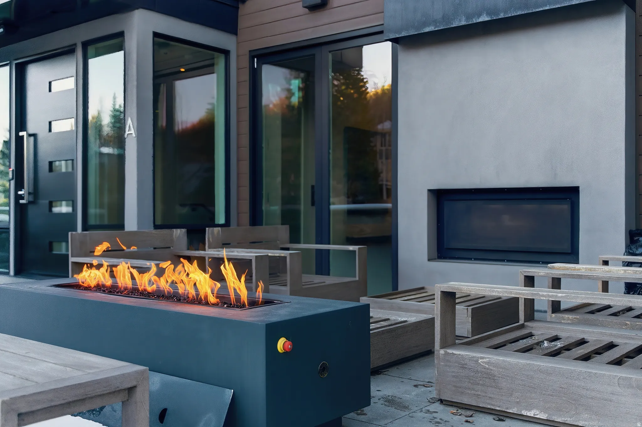 Outdoor patio featuring a modern fire pit, an exterior fireplace, and multiple glass doors