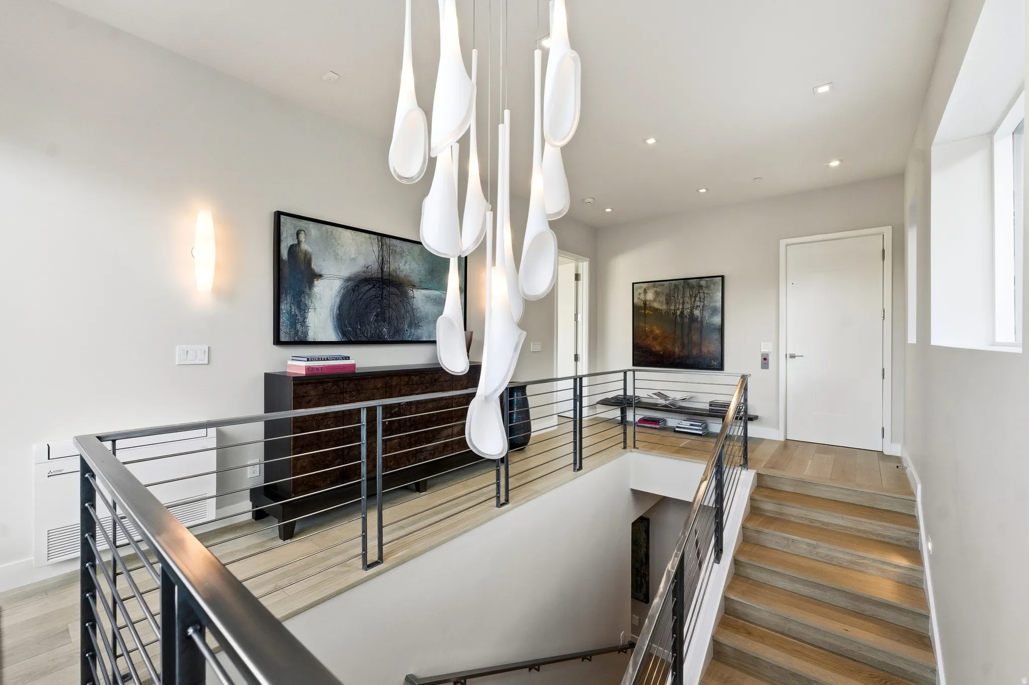 Contemporary open staircase with light wood-finish treads and metal railings