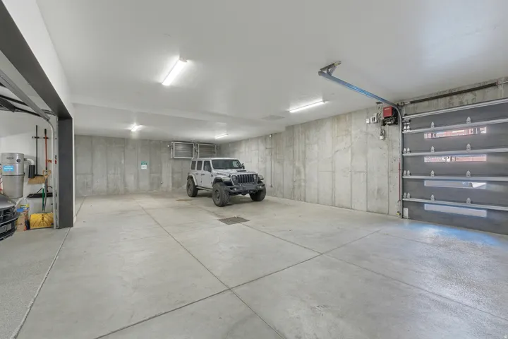 Spacious garage with concrete flooring and exposed concrete walls