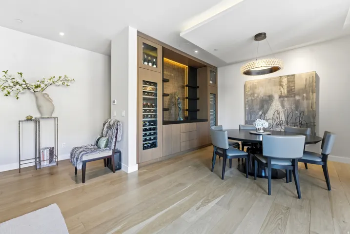 Integrated custom cabinetry with wine refrigeration, recessed lighting, and accent shelving