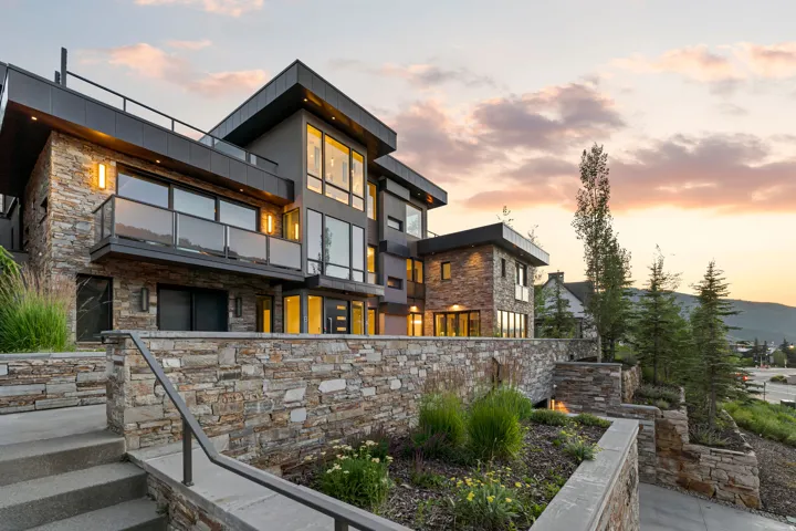 Modern architectural exterior featuring stone veneer and dark-toned siding