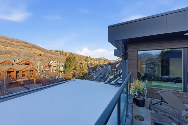 Balcony featuring a glass railing, dark metal framing, and a sliding glass door