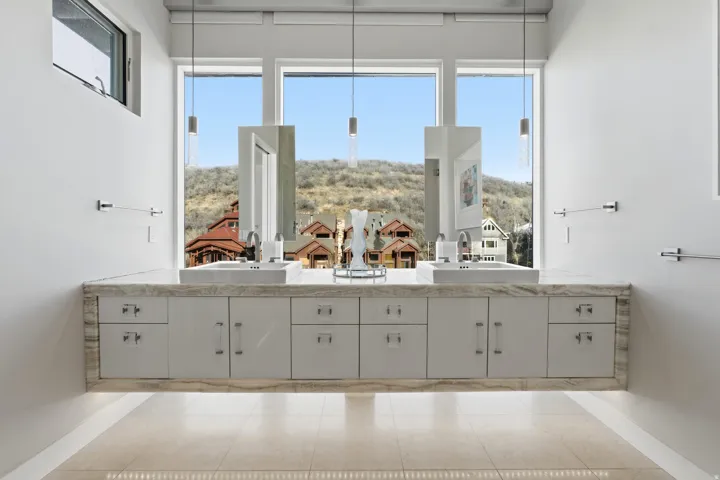 Dual vanity featuring a stone countertop, undermount sinks, and ample cabinetry