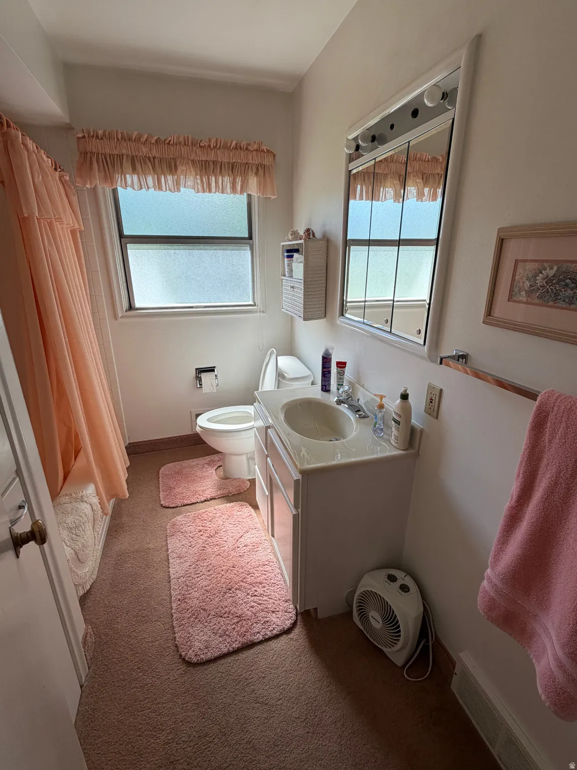 Bathroom featuring a single vanity with a solid surface countertop, an integrated sink, a built-in medicine cabinet with vanity lighting, and a window with privacy glass