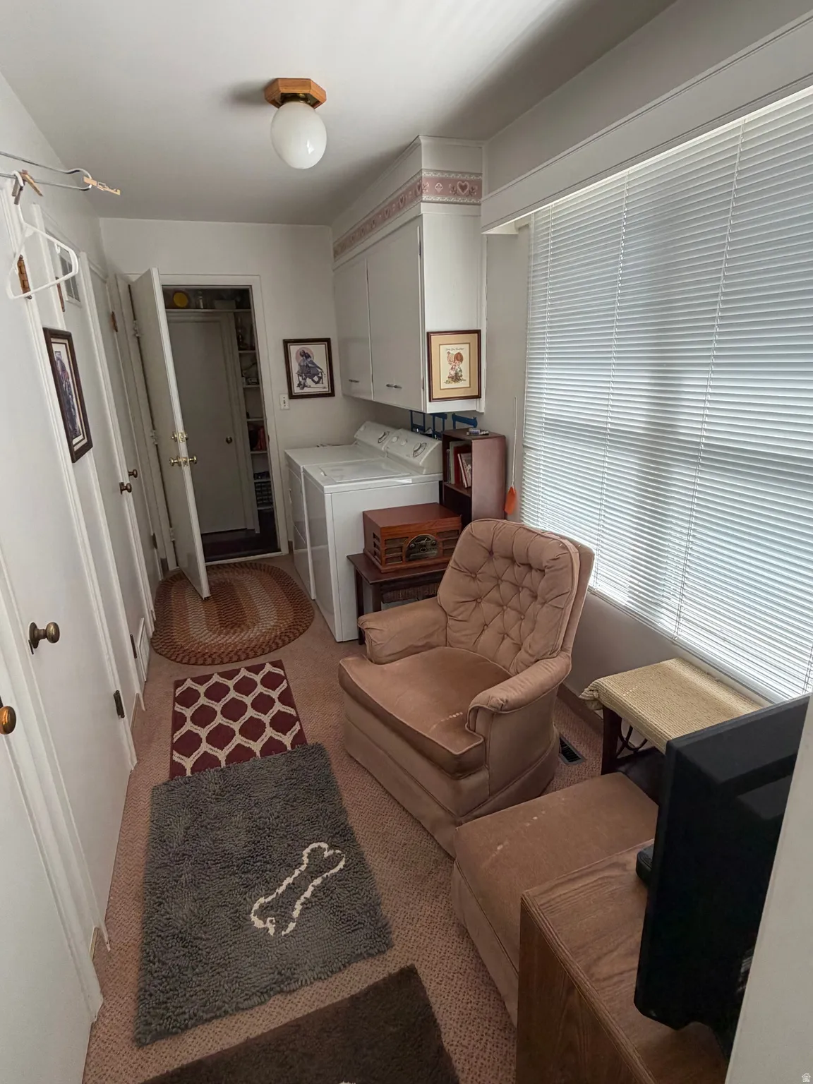 Laundry area featuring upper cabinetry, a window with blinds, and white appliances