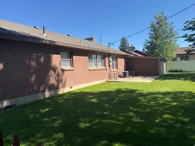 Brick exterior with a brown shingle roof and coordinating gutters