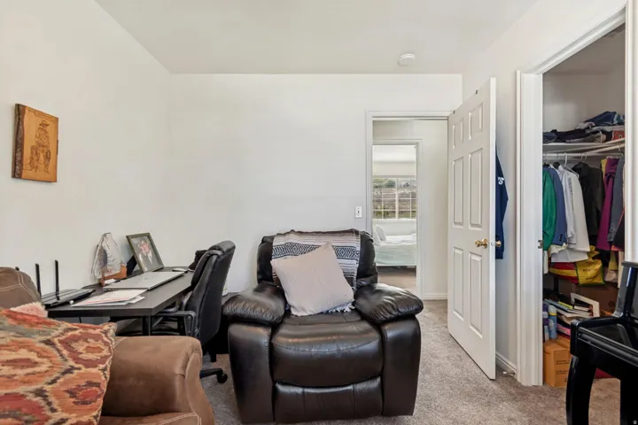 Carpeted interior space featuring white walls and a white six-panel door