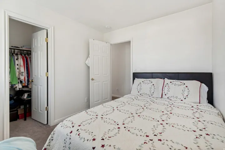 Bedroom featuring neutral wall color, carpet flooring, a closet with a bi-fold door, and a second interior door