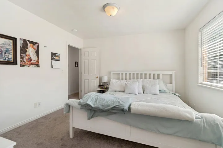 Carpeted room featuring light-colored walls, a window with horizontal blinds, and a flush-mount ceiling light fixture