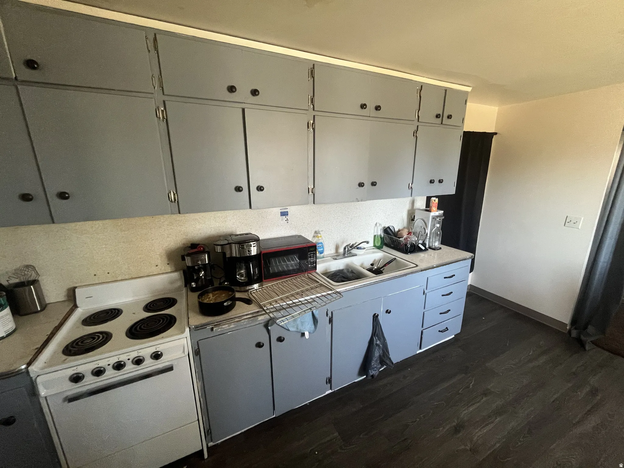 Kitchen featuring an electric range, double basin sink, and ample cabinet storage
