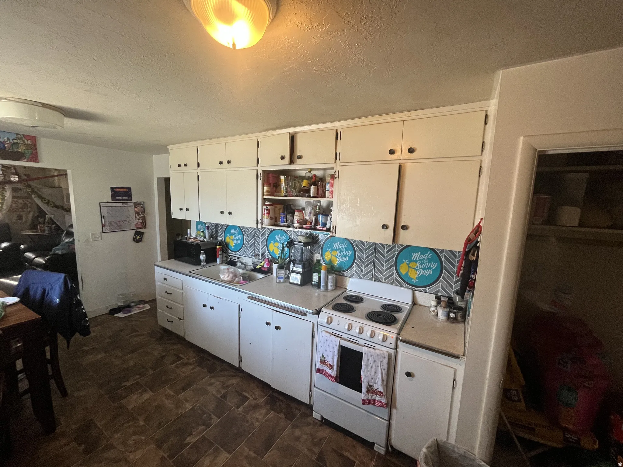 Kitchen featuring white cabinetry and a white electric range