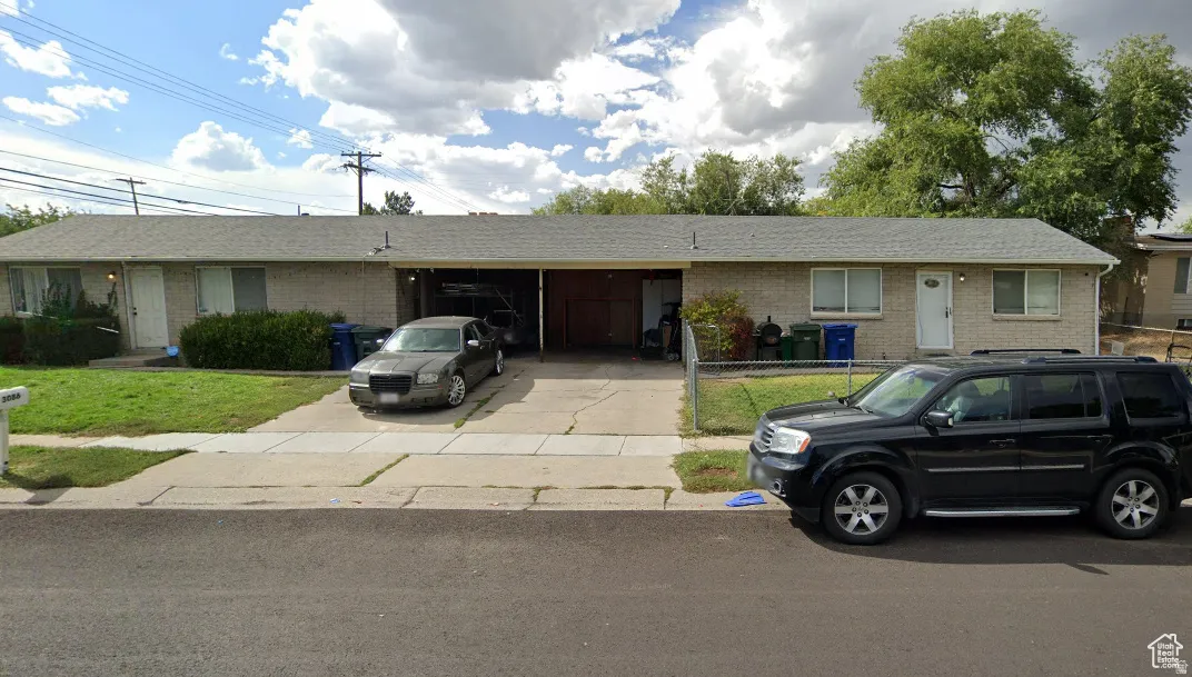 Single-story brick exterior featuring a shingle roof and a concrete driveway