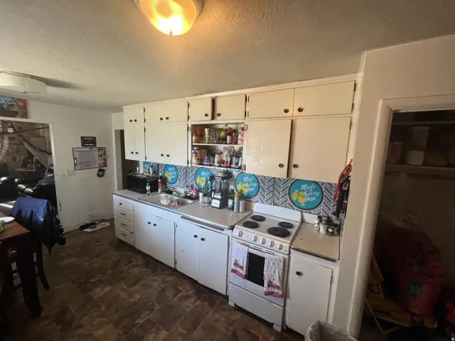 Kitchen featuring white cabinetry and a white electric range