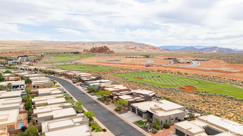 Modern desert community featuring a golf course, mountain backdrop, and contemporary flat-roof architecture