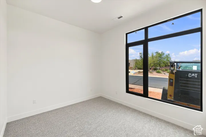 Expansive window with black framing, light gray carpeting, white walls, and a recessed ceiling light fixture