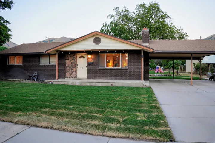 Ranch-style residence featuring a dark brick facade and a stone accent entryway