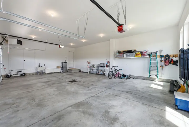 Spacious garage featuring a concrete floor, bright white walls, and recessed lighting