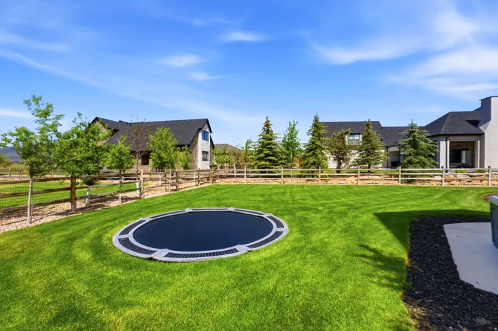 Expansive green lawn featuring an in-ground trampoline