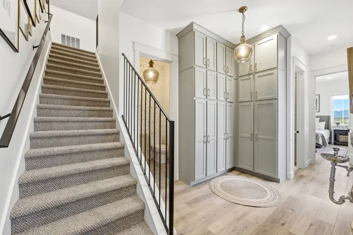 Staircase featuring carpeted treads and black metal railings