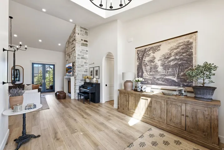 Spacious interior featuring wood-finish flooring, a vaulted ceiling with a large skylight, and recessed lighting