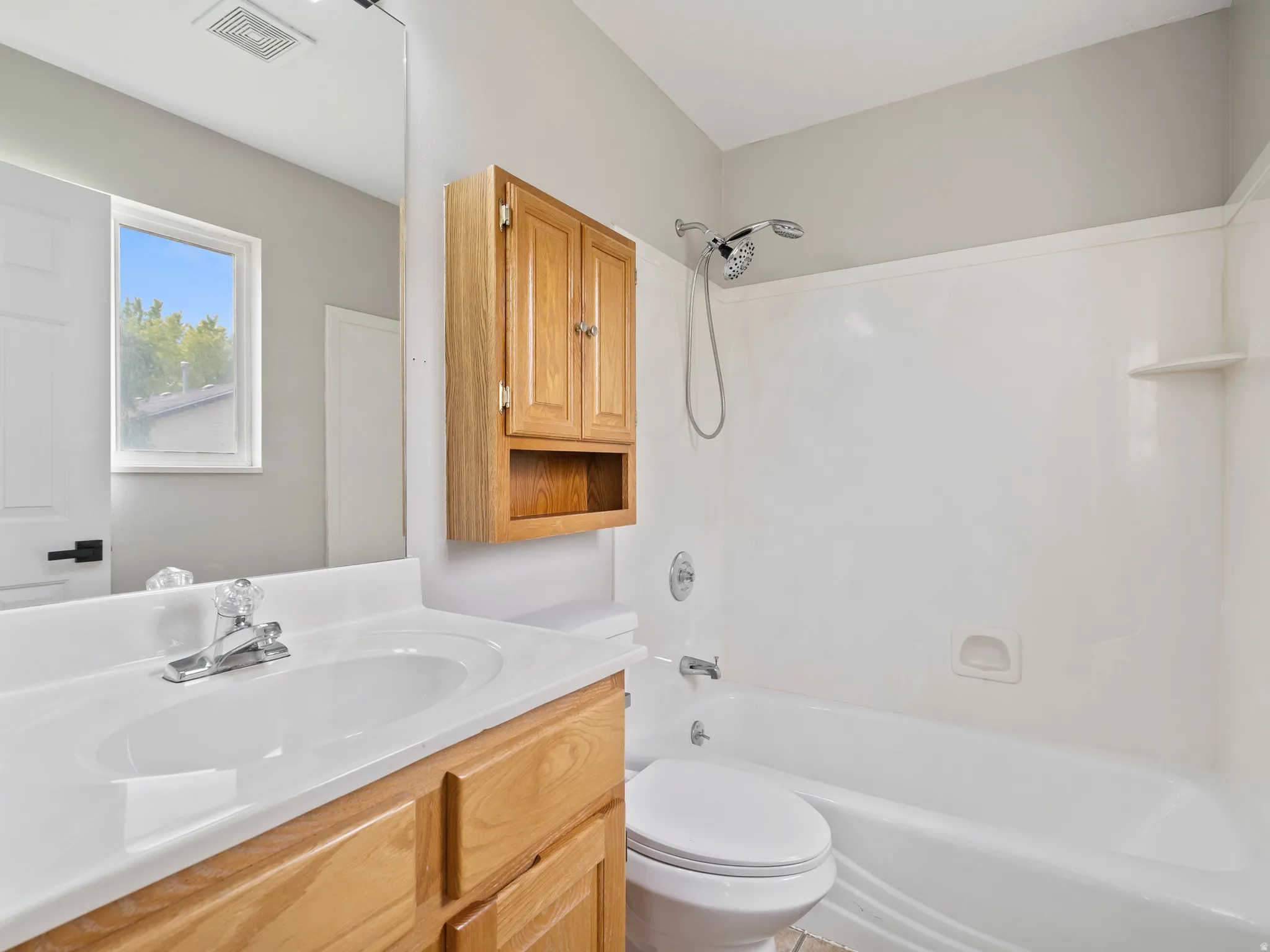 Bathroom featuring a single vanity with wood cabinetry, a white basin, and a chrome faucet