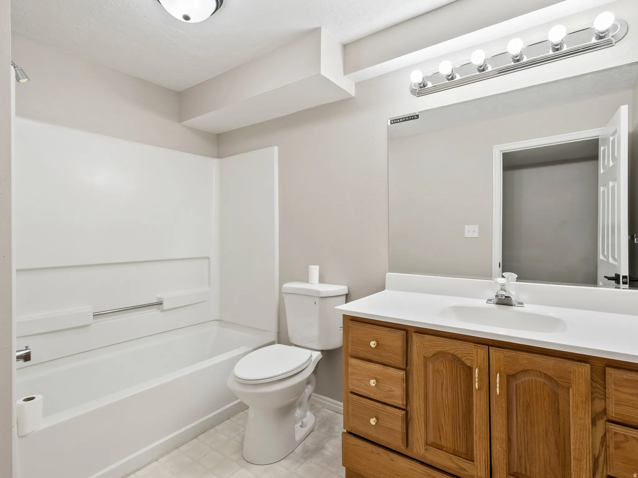 Bathroom featuring a light wood-finish vanity with a white countertop and integrated sink